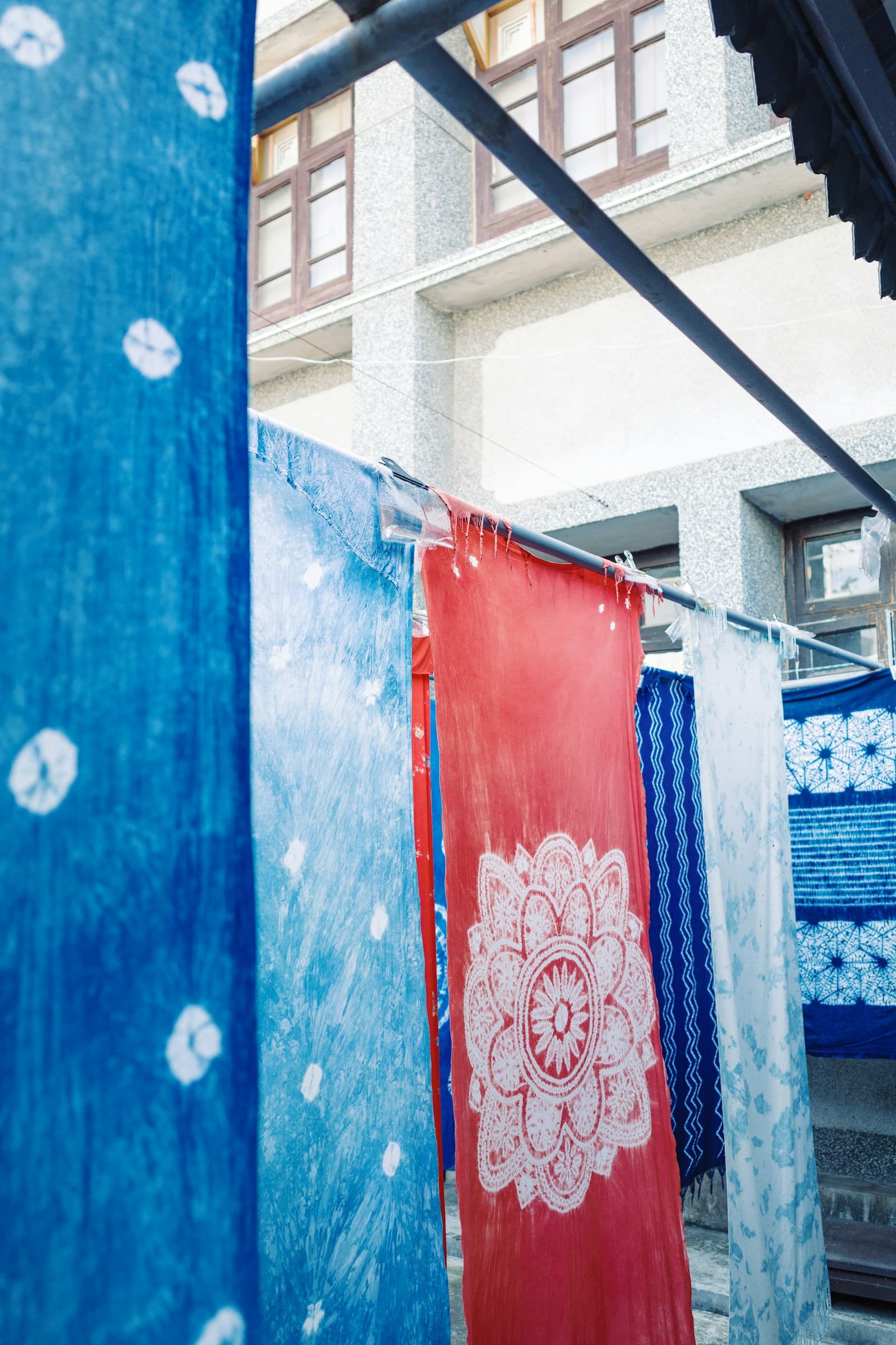 Dyed Bai fabrics drying in an indoor courtyard